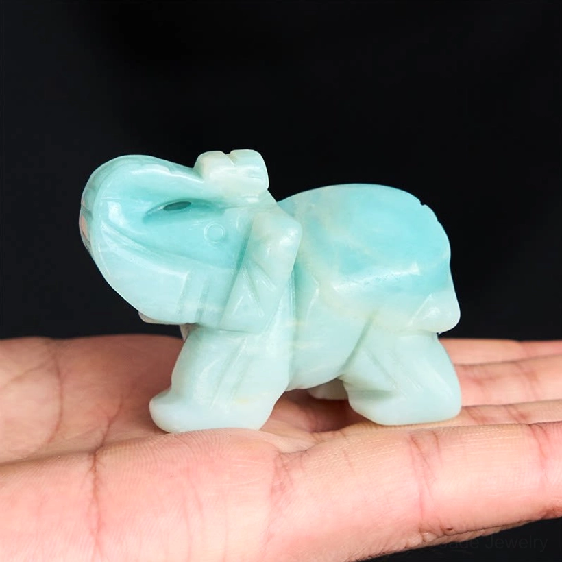 Pale cyan amazonite elephant held in palm showing small pocket-sized healing stone decoration