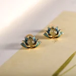 Hetian cyan jade lotus stud earrings flat lay with vintage paper background, showing gold-toned sterling silver and natural jade stone detail