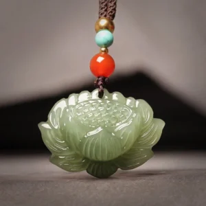 Hetian cyan jade lotus flower pendant necklace with red agate accents on brown cord, front overhead close-up view