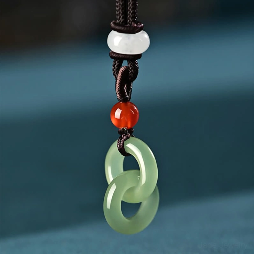 Close-up front view of cyan jade double peace buckle pendant with matching beaded braided cord