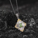 Hetian cyan jade rhombus pendant necklace with 925 sterling silver and gold plating, top-down view on black background
