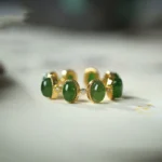 Hetian cyan jade adjustable ring with three oval green jade beads set in gold-toned sterling silver bezels, front view