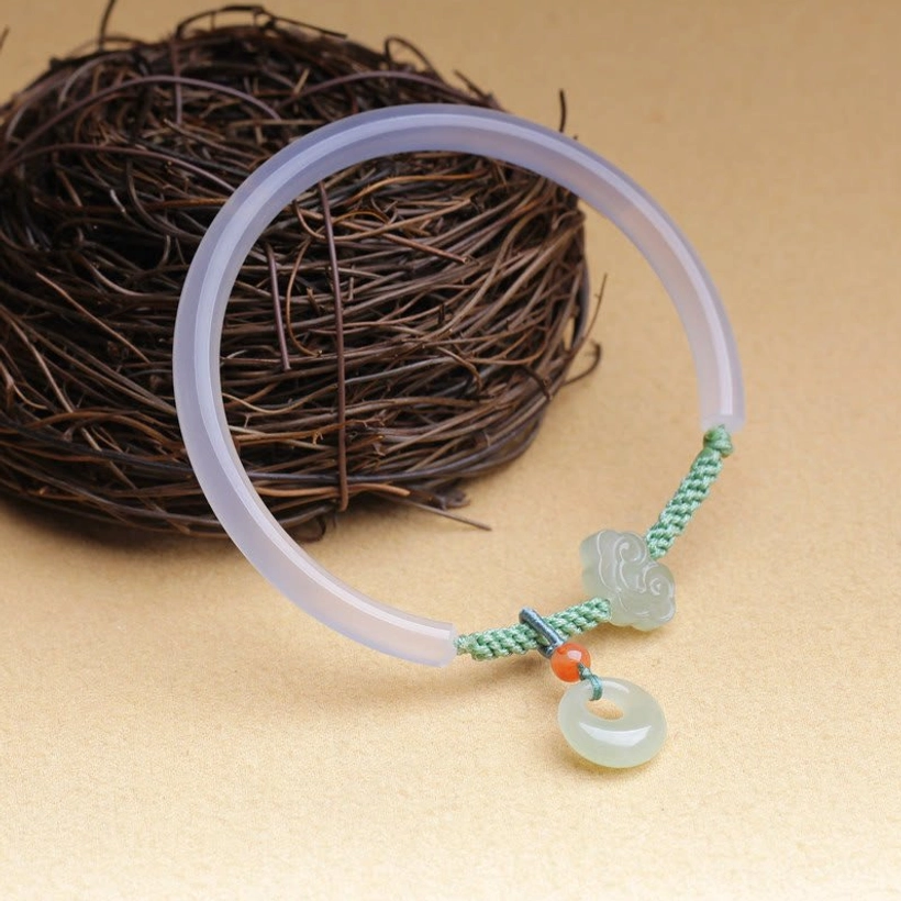 Full jade bracelet with all ornaments overhead view on dried twig nest, complete display of peace buckle and agate band