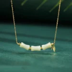 Hetian jade bamboo fu character necklace 925 sterling silver front view dark green background