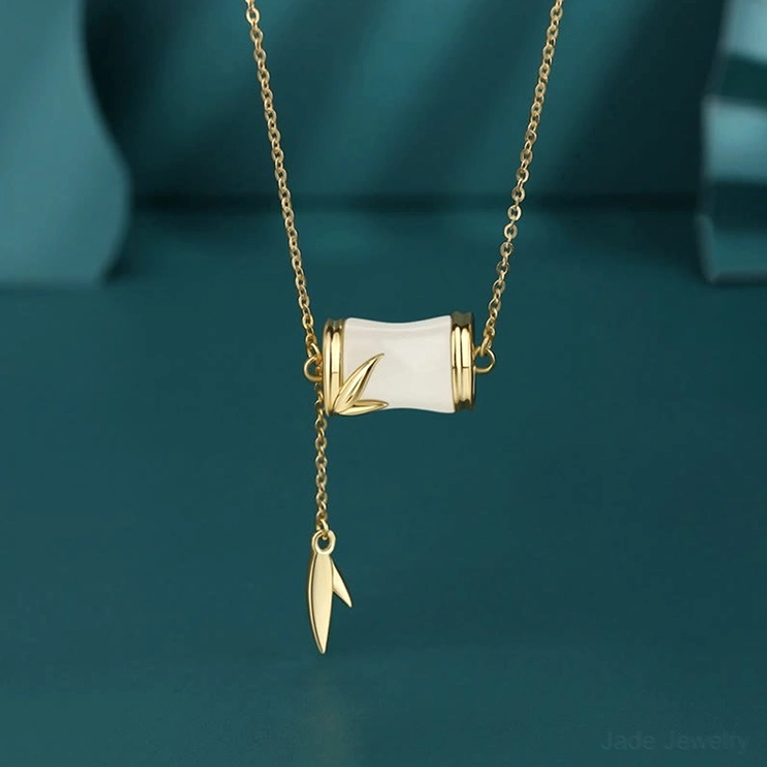 Gold-plated Hetian white jade bamboo Y-necklace close-up featuring adjustable chain with 22K gold accents, intricately carved jade bamboo charm, and leaf tassel pendant detail