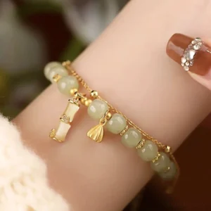 Hetian jade lotus bamboo charm bracelet worn on wrist – double-layer design with green jade beads and gold pendants, everyday styling