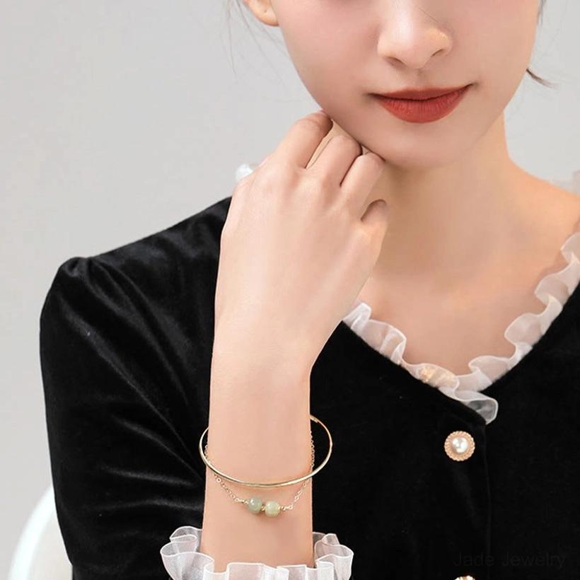 Hetian jade bangle bracelet one bead configuration with gold plated hardware on display tray