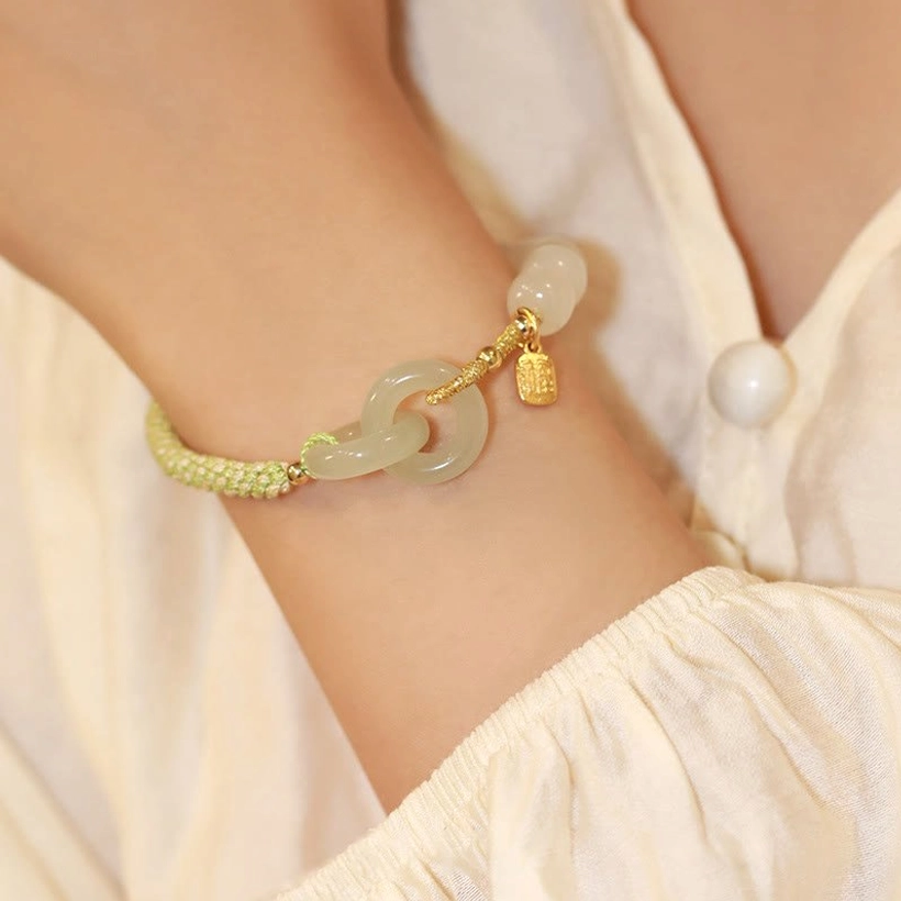 Hetian jade double peace buckle bracelet side view with green cord and small jade bead accent