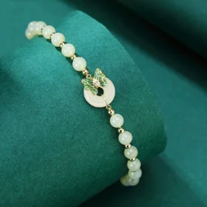 Sterling silver jade peace buckle bracelet displayed on green velvet cylinder - side angle view with elastic band detail