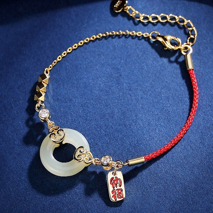 Side view of hetian jade bracelet with twisted sterling silver chain section, red cord, and engraved fortune charm tag