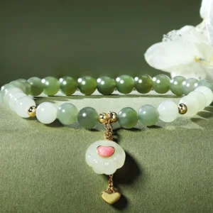 Double strand Hetian jade cat paw charm bracelet close-up detail with matching heart pendant and gold accents