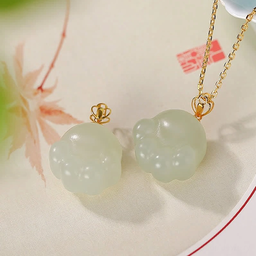 Hetian white jade cat paw pendant necklace flat lay with oriental plate and maple leaf decoration showing multiple pendant designs