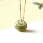 Hetian jade child lock pendant necklace with gold chain - natural olive-green donut jade charm overhead front view