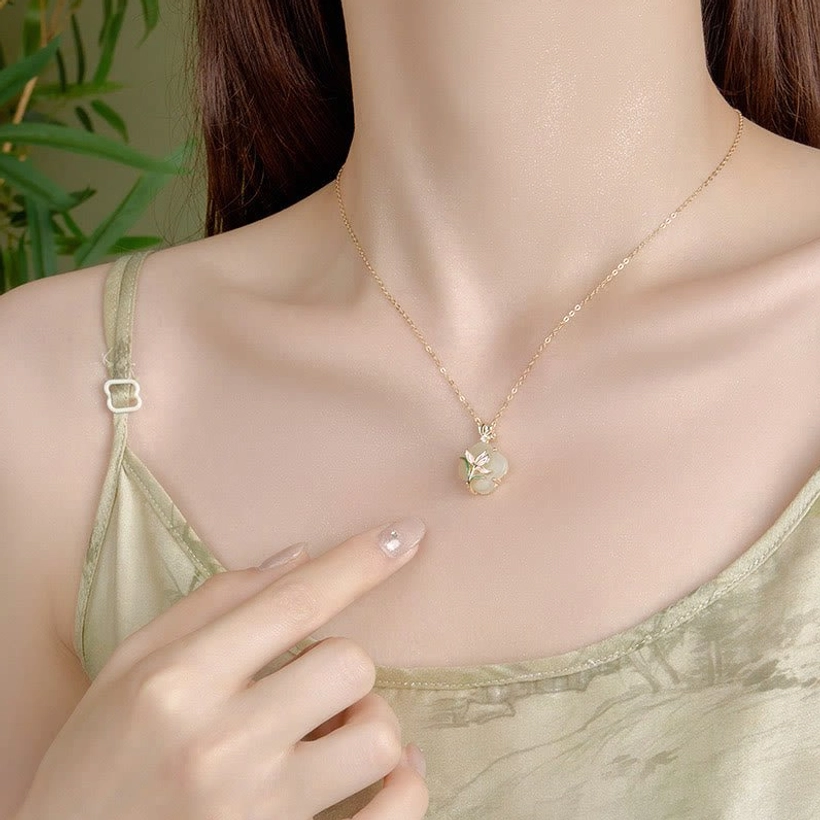 Hetian jade four leaf clover pendant necklace worn on collarbone showing slim gold chain and subtle pendant design