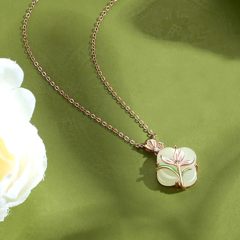 Hetian jade four leaf clover necklace pendant with enamel magnolia and butterfly on gold chain green fabric background