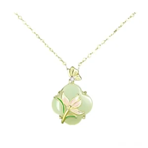 Close-up studio shot of Hetian jade four leaf clover necklace pendant featuring pink enamel magnolia flower and butterfly bail with diamond accent