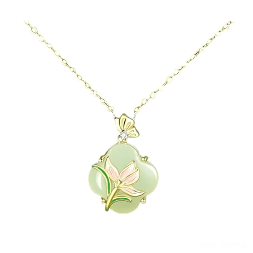 Close-up studio shot of Hetian jade four leaf clover necklace pendant featuring pink enamel magnolia flower and butterfly bail with diamond accent