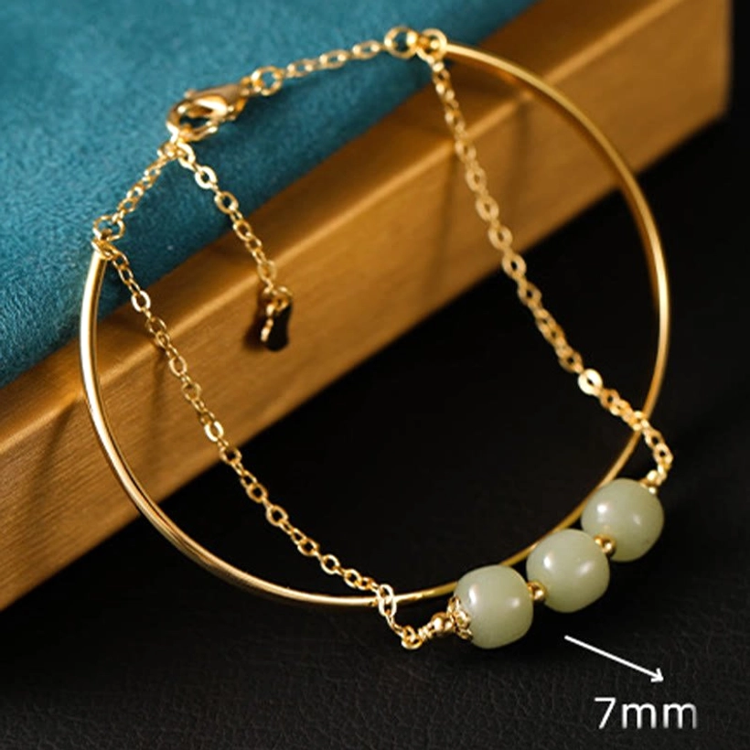 Front side view of hetian jade double layer bangle bracelet with seven millimeter beads and four jade beads on gold chain layer