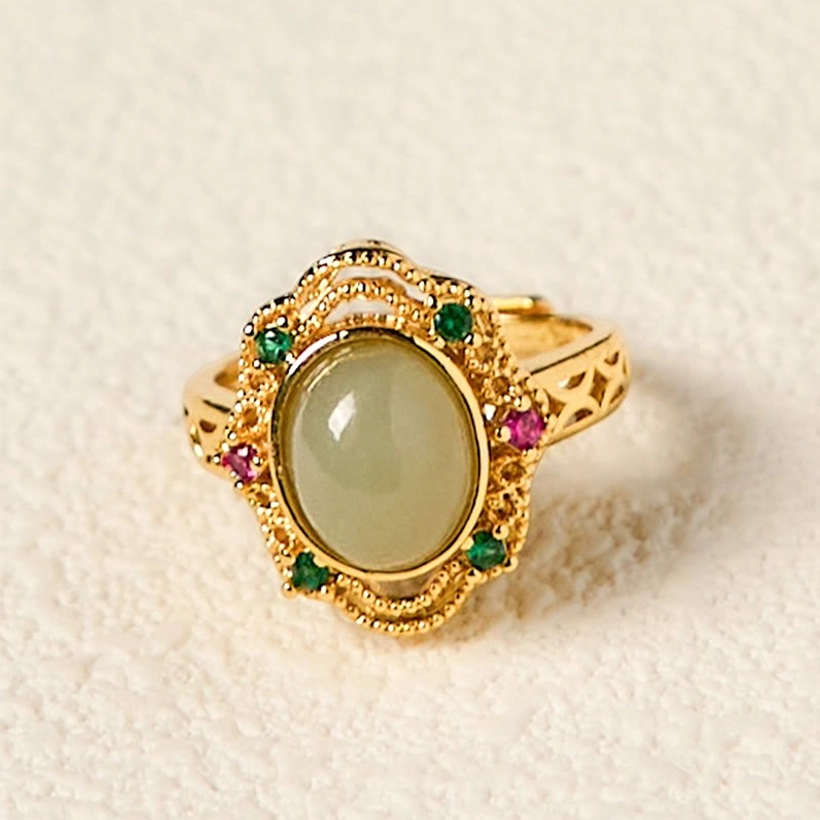 Natural hetian jade egg ring with carved hollow band pattern, overhead front view on neutral backdrop highlighting the oval jade stone center