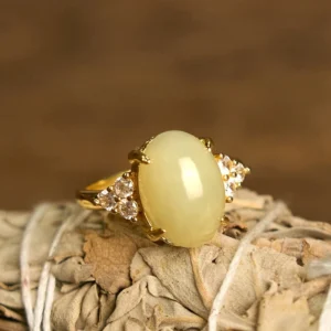 Hetian jade egg ring with gold alloy setting featuring pale yellow jade centerpiece and side crystal accents