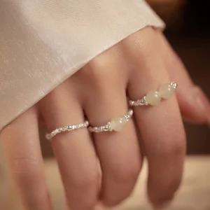 Hand wearing stackable Hetian jade elastic rings with 925 sterling silver beads - daily wear jewelry display