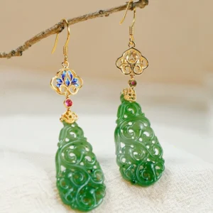 Hetian jade enamel dangle earrings with blue cloisonné flower top, red gem accent, and carved green jade pendant hanging on decorative twig