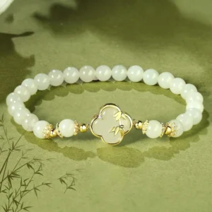 Hetian jade four leaf clover bamboo bracelet with sterling silver accents on green background