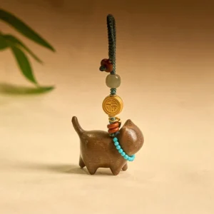 Hetian jade sandalwood cat keychain with Fu character charm and turquoise beaded collar, front view on light studio background