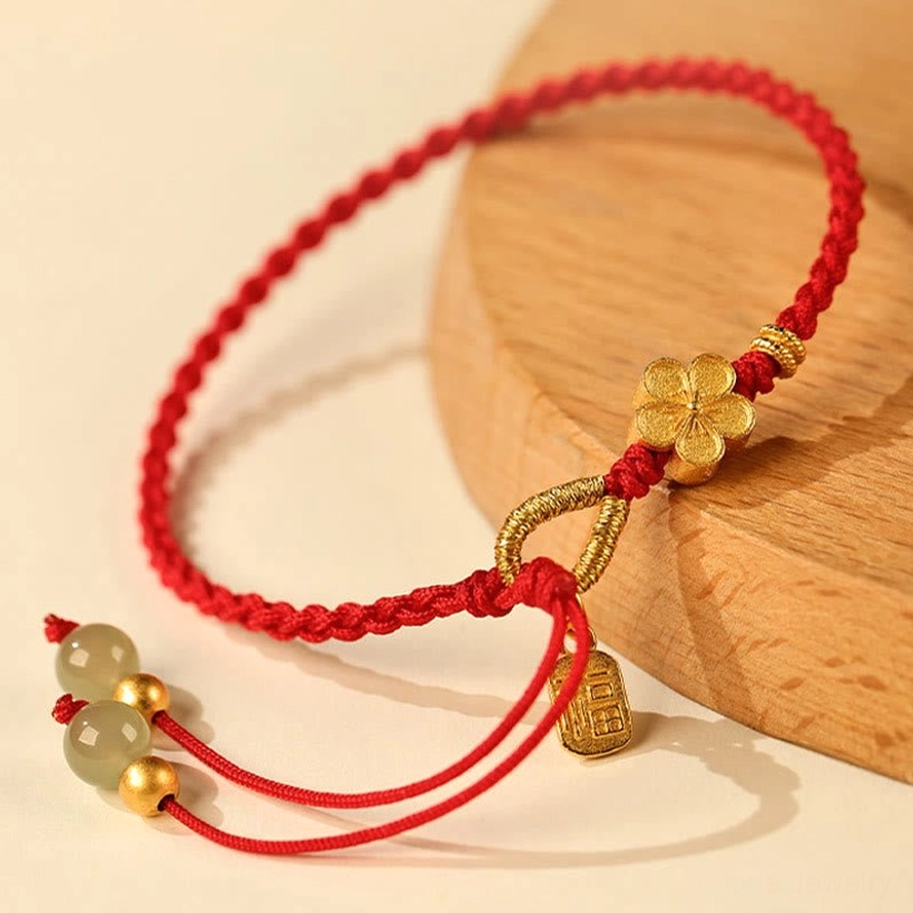 Hetian jade fu character peach blossom bracelet side view on wooden coaster showing complete charm arrangement