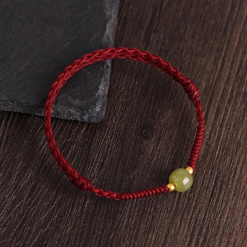 Hetian jade gold bead red string bracelet with stone prop overhead view