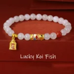 Hetian white jade koi fish lucky bracelet with red agate and 925 sterling silver charm on red velvet background, top-down flat lay view