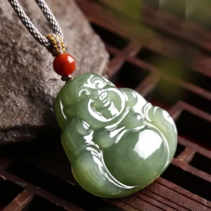 Hand-carved Maitreya Buddha Hetian jade pendant with glossy polished finish shown at oblique angle on stone background