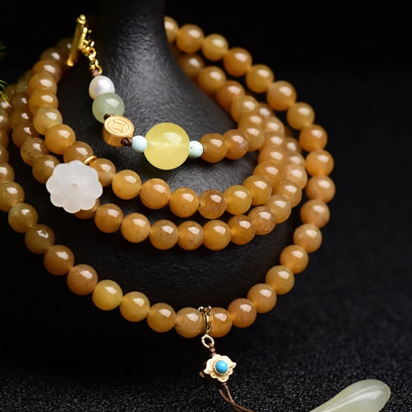 Hetian jade mala bracelet with brown jade beads, white jade lotus, and turquoise details on black stand