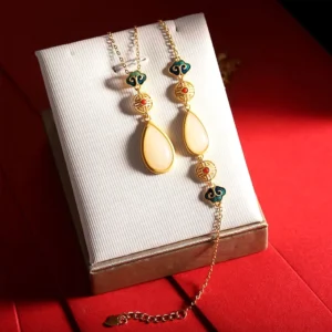 Hetian white jade water drop necklace and bracelet set displayed with enamel cloud accents and vintage Chinese motifs on gold-plated sterling silver