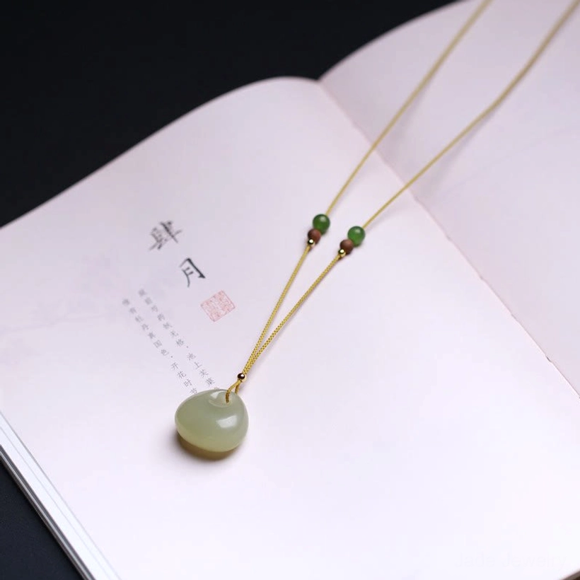 Hetian jade charm necklace worn styled shot, prosperity pendant at chest level demonstrating daily wear versatility