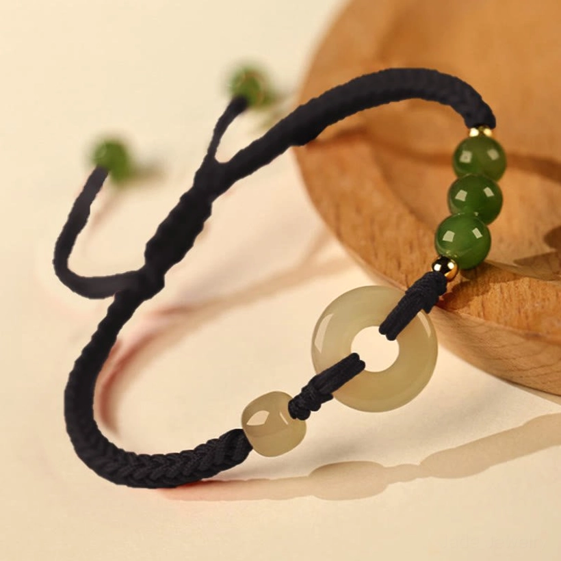 Black rope Hetian jade peace buckle bracelet alternative color option with jade beads on wooden surface