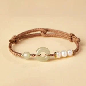 Hetian jade peace buckle bracelet with freshwater pearls and gold spacers on beige background