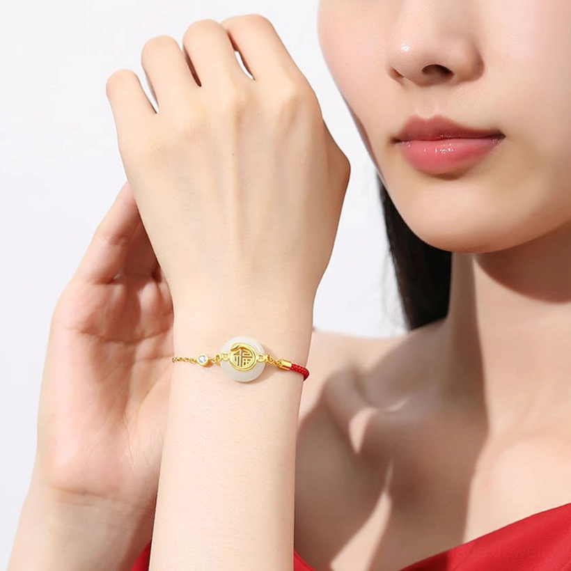 Model wearing Hetian jade peace buckle red string bracelet on wrist, lifestyle studio shot