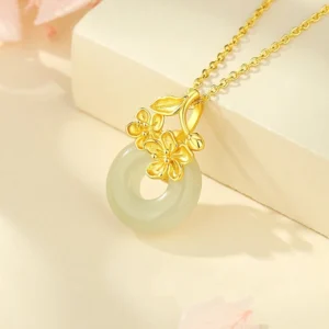 Gold Hetian jade peace buckle necklace with floral details shown with product box