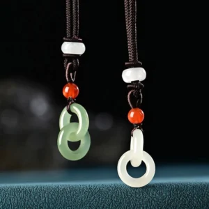 Hetian jade double peace buckle necklace in cyan and white jade variants, displayed with brown braided cord and red agate spacer beads