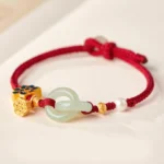Red braided Hetian jade peace buckle fortune bracelet with gold lotus charm and white pearl flat lay