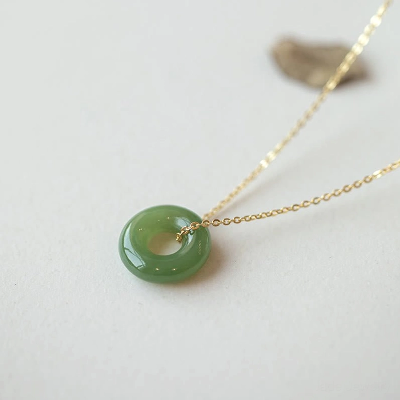 Hetian jade peace buckle necklace three-quarter side view with smooth green pendant on gold-plated sterling silver chain and decorative stone accent