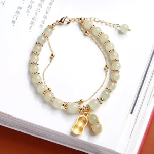 Double-layer Hetian jade peanut charm bracelet adjustable chain gold bead accents flat lay