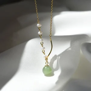 Hetian jade pendant necklace with clustered pearl chain and curved gold hardware, side close-up detail