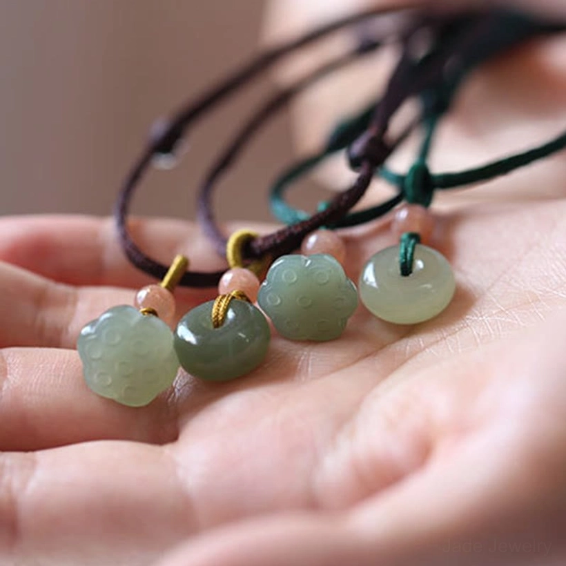 Hetian jade pendant necklace showing natural color variations and hand-carved texture