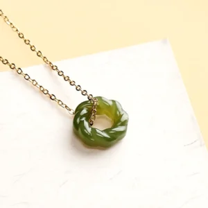 Hetian jade blessing pendant necklace with delicate cable chain, overhead angle showing intricate carved twist design