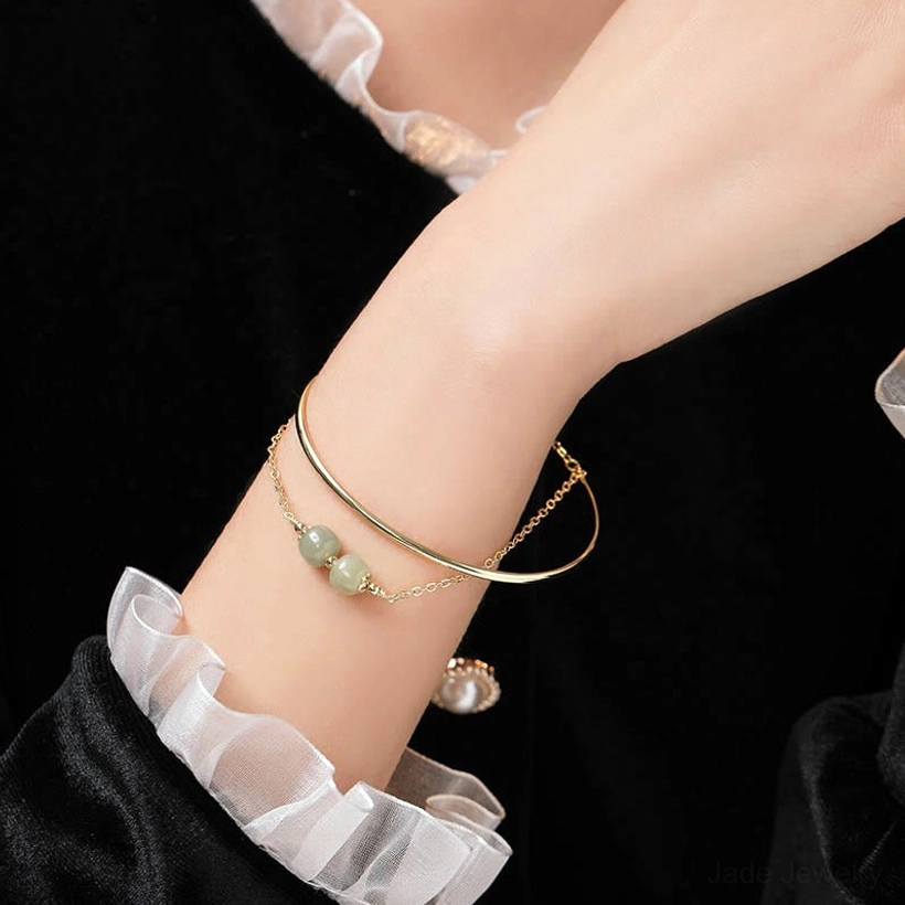 Hetian jade bangle bracelet prosperity charm showing authentic nephrite stone with natural light green coloring