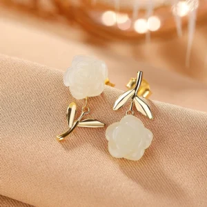 Close-up of gold-plated Hetian jade rose earrings with carved jade blossoms and gold leaf posts