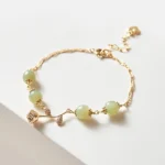 14K gold plated Hetian jade rose flower bracelet flat lay top-down view white background