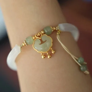 Hetian jade ruyi lock cuff bracelet worn on wrist, showing adjustable band with jade pendant and tassel details